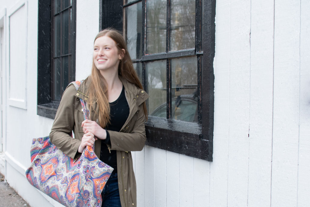 Rachel walking into the yoga studio with a yoga mat bag